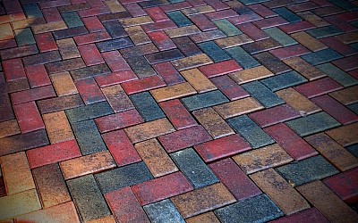 A beautiful paver patio, with an interlocking,herringbone, tri colored design